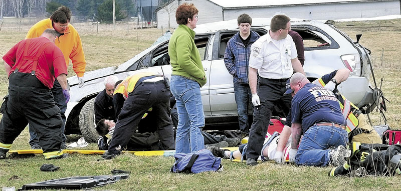 CRASH: Passengers are treated after the Chevrolet Equinox they were in rolled over before coming to rest off Garland Road in Winslow on Monday. Eyewitness Brenda Pelletier, who lives nearby, said the vehicle appeared to overcorrect and go into a fishtail before going airborne, then rolled.