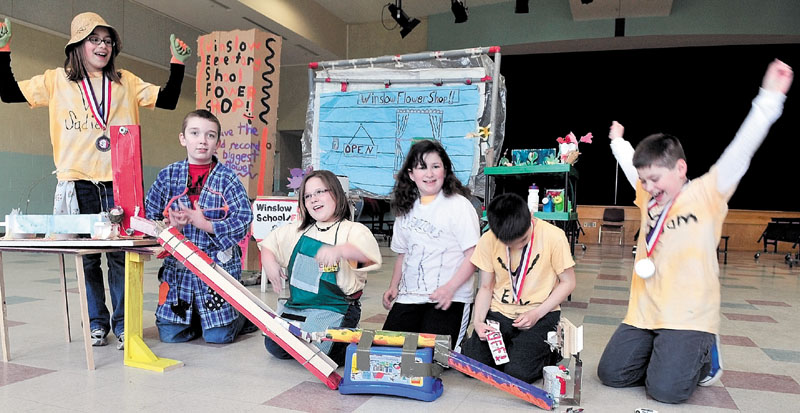 IT WORKS: Members of the Winslow Elementary School Odyssey of the Mind team react with cheers after practicing with their Rube Goldberg invention that replaces the common watering can on Monday. The team is preparing to raise money to compete in the World Finals of the Odyssey of the Mind competition in Maryland.
