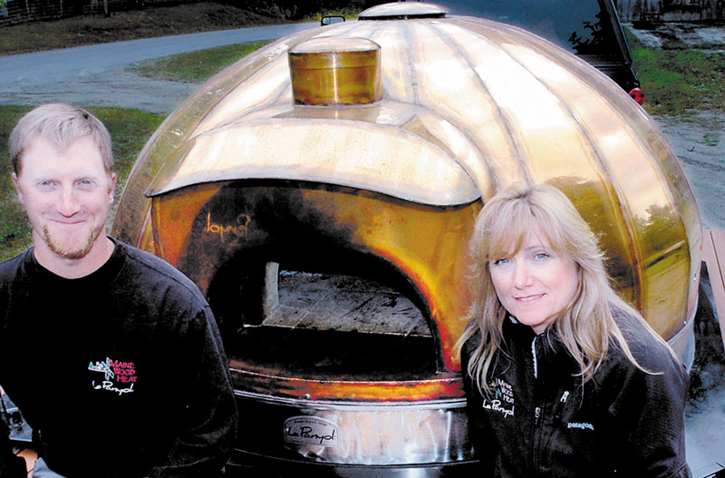 MOBILE HEAT: Scott and Cheryl Barden beside a mobile oven that they assemble and sell at their Maine Wood Heat. The former Norridgewock company has relocated to the Northgate Industrial Park in Skowhegan.