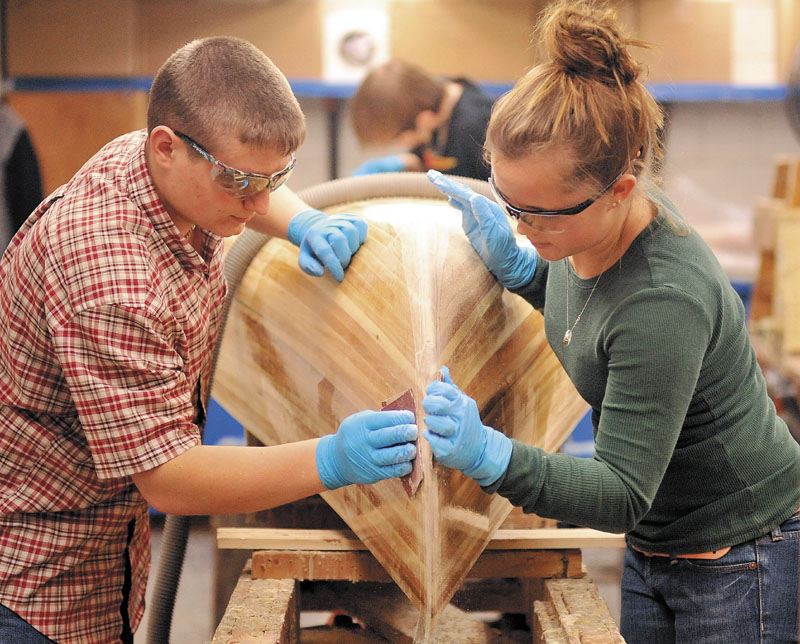 SHIPSHAPE: Ivan Beaulieu, left, and Megan Orchard work on a canoe they built from scratch in the Outdoor Resources class during the skills showcase at the Somerset Career & Technical Center in Skowhegan Wednesday.
