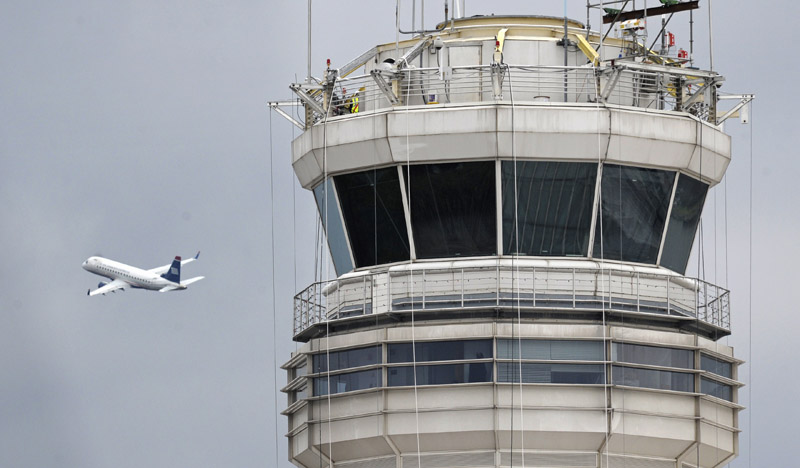 A passenger jet flies past the FAA control tower recently at Washington's Ronald Reagan National Airport, where a control tower supervisor who was unavailable to aid two airliners was suspended in March.
