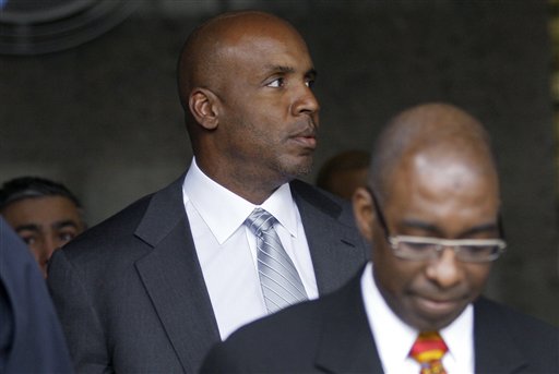 Former baseball player Barry Bonds, left, leaves federal court Tuesday in San Francisco. Prosecutors rested their case against Bonds in his perjury trial Tuesday.