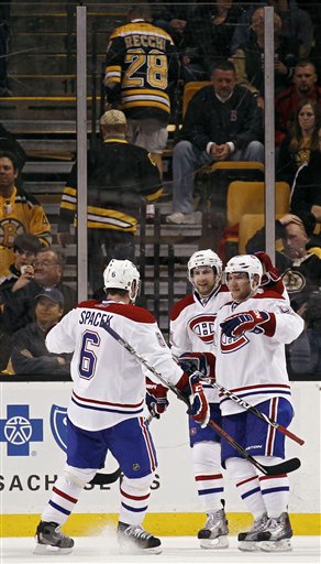 Boston Bruins fans walk up the stairs as Montreal's Yannick Weber, bottom right, is congratulated by teammates Tom Pyatt and Jaroslav Spacek (6) after scoring against the Bruins during the second period of the Canadiens 3-1 win in Game 2 of their first-round playoffs series Saturday in Boston.