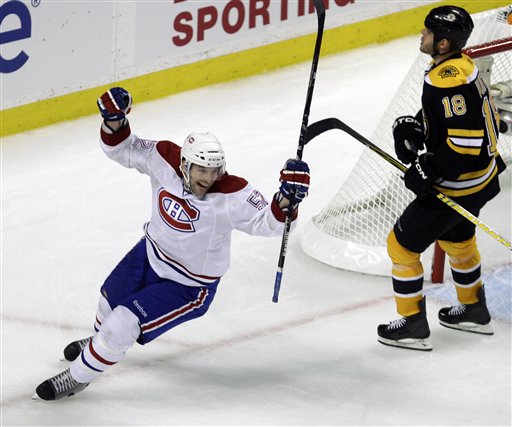 Montreal Canadiens left wing Mathieu Darche, left, skates past Boston's Nathan Horton while celebrating a goal by teammate Brian Gionta during the third period the Canadiens 2-0 win in Game 1 of their playoff series Thursday in Boston.