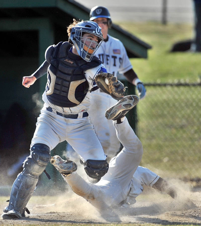 Staff photo by Michael G. Seamans Colby College catcher, John Schroeder, 9, tags out Tufts University's David LeResche, 2, at home in the third inning of baseball action at Coombs Field at Colby College in Waterville Friday afternoon.