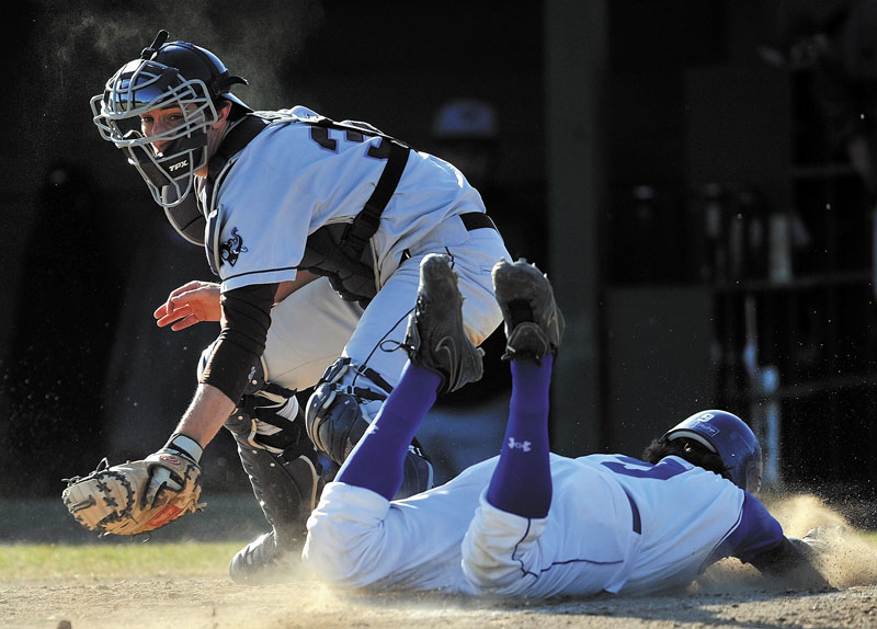 SAFE: Colby’s John Schroeder dives in to home plate before Tufts University catcher Matt Collins, left, can apply the tag in the first inning Friday at Coombs Field at Colby College in Waterville.
