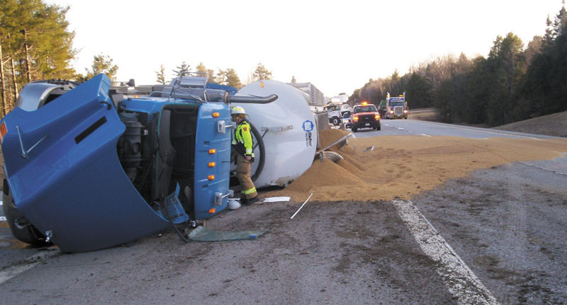 Emergency crews work Friday to right an 18-wheeler that rolled over at 6:40 a.m., blocking the southbound lanes of Interstate 95. The truck’s driver, Nelson Plourde, 51, of Gardiner, was taken to MaineGeneral Medical Center in Augusta with a severe cut on an elbow. The truck had just loaded grain at Blue Seal Feeds on Riverside Drive.