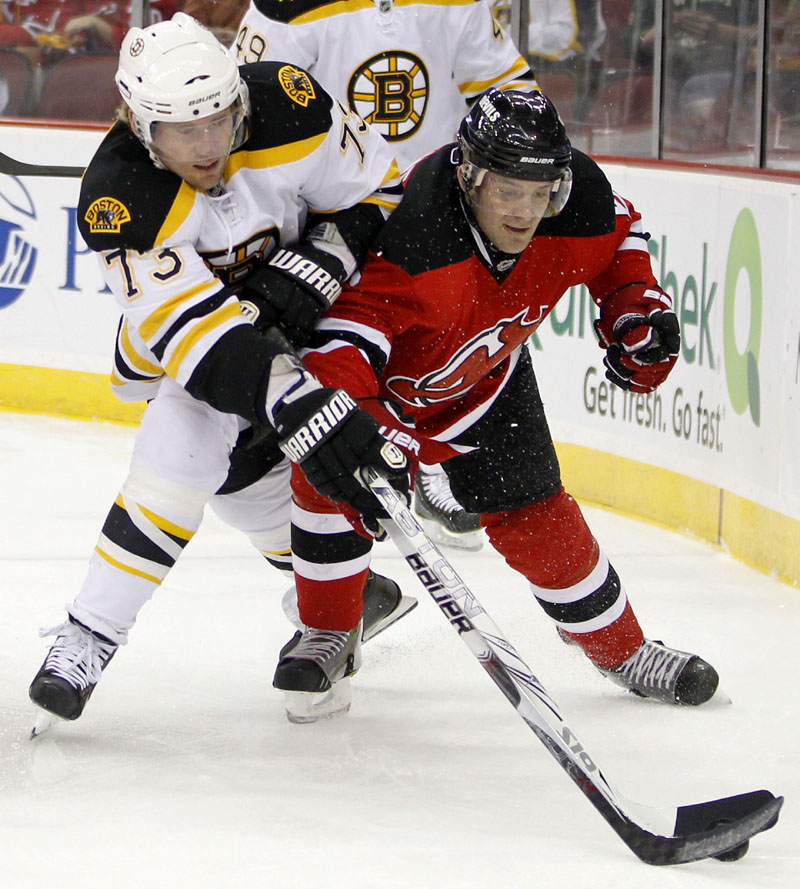 GIVING CHASE: Boston Bruins right wing Michael Ryder, left, and New Jersey Devils defenseman Andy Greene compete for the puck in the first period Sunday in Newark, N.J. The Bruins lost the regular-season finale, 3-2.