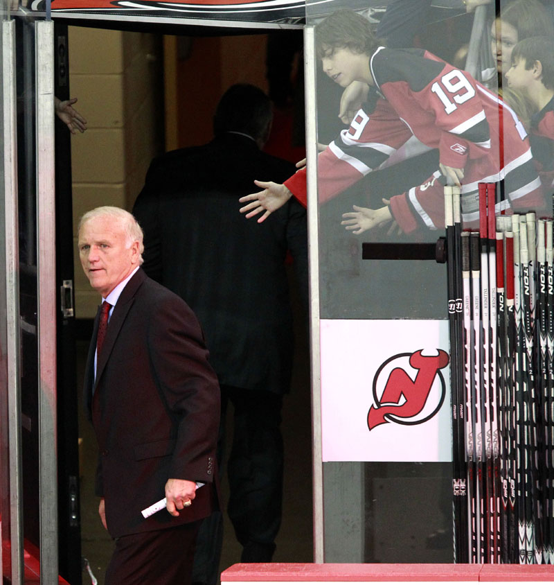WALKING AWAY: New Jersey coach Jacques Lemaire, left, looks back before exiting the bench at the end of the Devils’ 3-2 victory against the Boston Bruins on Sunday in Newark, N.J. Lemaire, who came out of retirement in December, announced after the game that he would go back into retirement.