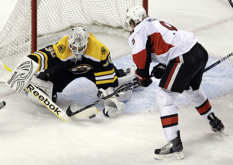 Puck stops here: Boston Bruins goalie Tim Thomas, left, makes a stick save as Ottawa’s Milan Mihalek looks for a rebound during the first period of their game Saturday in Boston. Thomas had 31 saves to help the Bruins win 3-1.