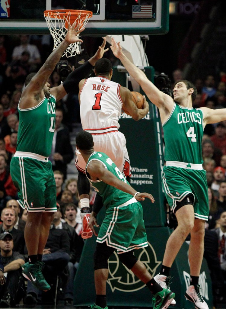 SLICING UP THE DEFENSE: Chicago Bulls guard Derrick Rose, center, drives to the basket against Boston Celtics defenders Glen Davis, left, Rajon Rondo, bottom, and Nenad Krstic during the first quarter Thursday night in Chicago. Rose scored a game-high 30 points as the Bulls won 97-81 and moved closer to clinching the No. 1 seed in the Eastern Conference.