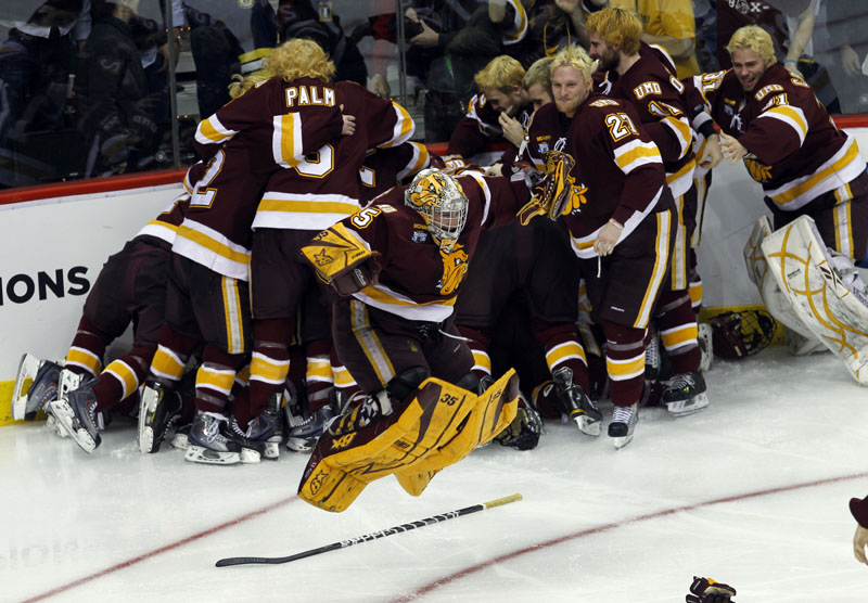 1ST-TIME CHAMPIONS: Minnesota Duluth goalie Kenny Reiter, center, leaps in the air as his teammates celebrate in the background after beating Michigan 3-2 in overtime in the championship game Saturday night in St. Paul, Minn. It's the first championship in Minnesota Duluth's history.