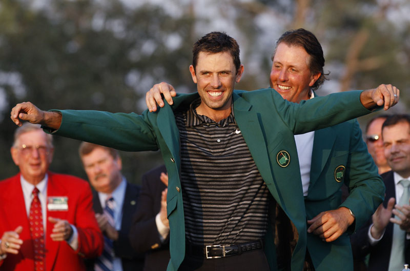 NEW WINNER: Former Masters champ Phil Mickelson, back, helps Charl Schwartzel put on his green jacket after winning the Masters on Sunday evening in Augusta, Ga.