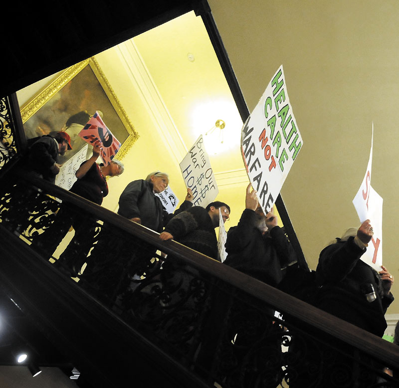 Protesters gathered at the Statehouse Monday to voice opposition to a variety of issues, including war funding and the removal of murals from the Maine Department of Labor.