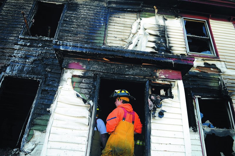 Firefighters inspect the interior of an apartment building that burned Saturday night and Sunday morning on Route 226 in Randolph. The blaze is under investigation by authorities.