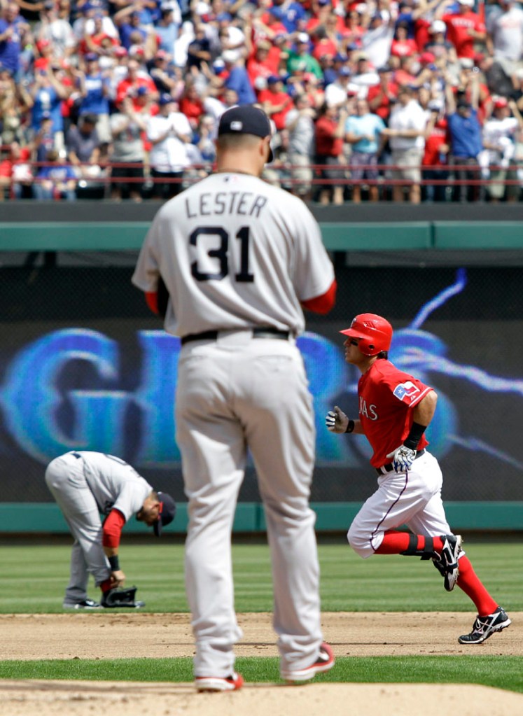 NOT IDEAL START: Boston Red Sox pitcher Jon Lester, left, walks to the back of the mound as Texas Rangers second baseman Ian Kinsler rounds the bags following his leadoff home run in the first inning Friday in Arlington, Texas. Lester allowed five runs — and three home runs — in 5 1/3 innings.