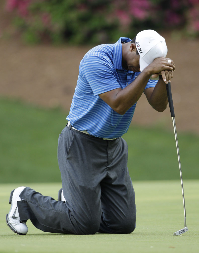 OH, SO CLOSE: Tiger Woods falls to his knees after missing an eagle putt on the 13th hole during the third round of the Masters on Saturday in Augusta, Ga. He made the birdie putt.