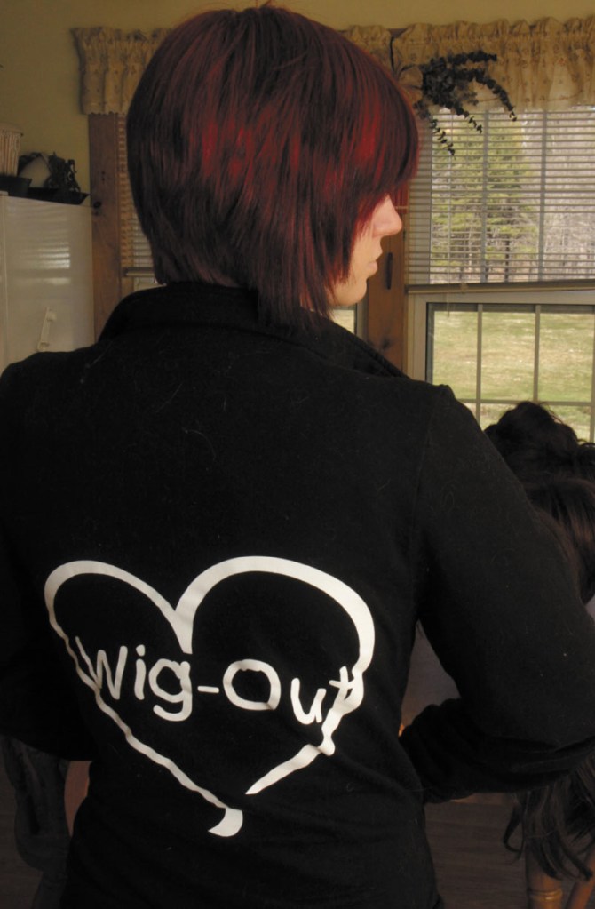 Rachel Fortin, 19, of West Gardiner wears a sweatshirt promoting her home business called Wig-Out which was started to help cancer patients and other people who have lost their hair find a sense of confidence in dealing with their illness. Fortin said her boss at Shania Boyton at Access Worldwide in Augusta, who is a cancer survivor, inspired her to start the business.