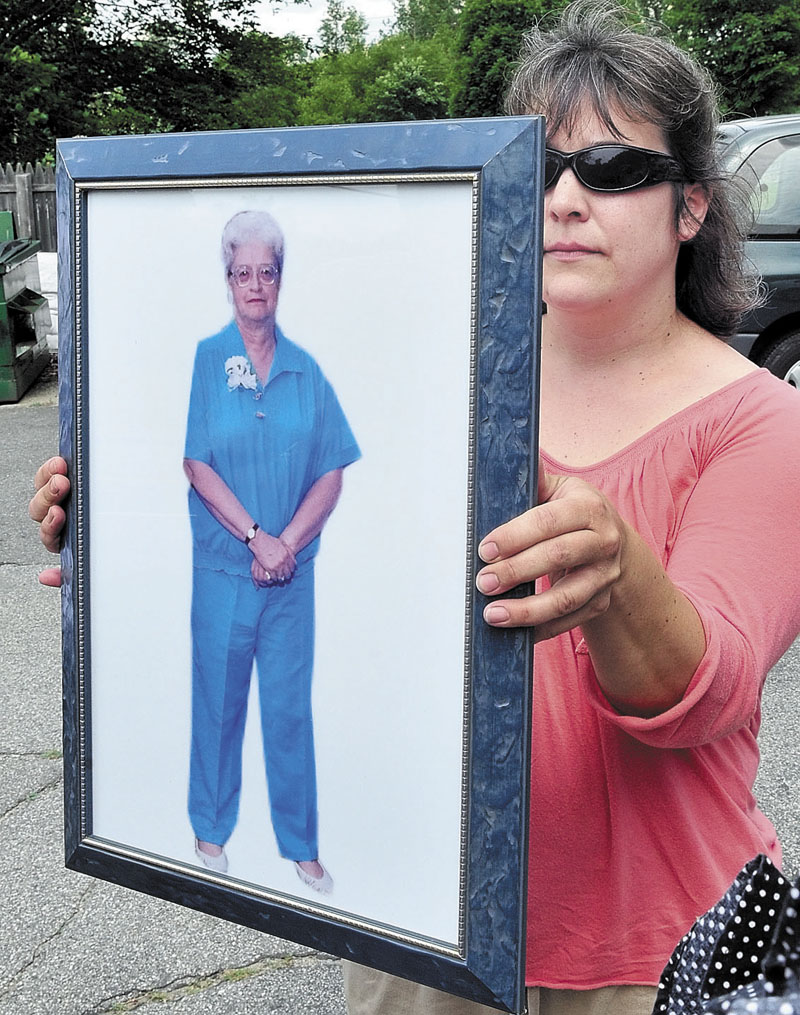 FAMILY: Sheila Butterfield holds a portrait of her relative, Grace Burton, during a press conference earlier this month at the Farmington apartment where Burton was killed on June 21.