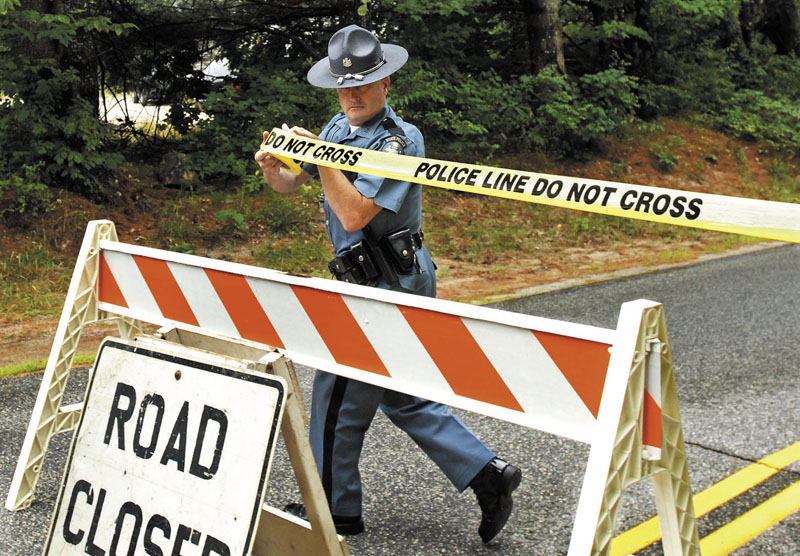 CLOSED: Maine State Police Trooper Steven Green seals off part of Bennett Road in New Gloucester on Tuesday while investigators collected evidence after a fatal shooting on Monday night.