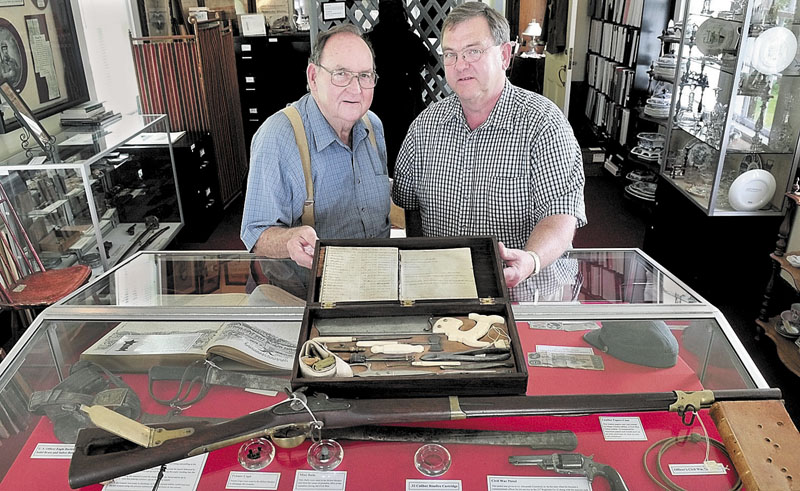 HISTORY LESSON: Lee Granville, left, curator of the Skowhegan History House Museum & Research Center, and Director Melvin Burnham, display a surgeon’s kit of instruments next to a rifled musket for the “Our Connections with the Civil War” exhibit.