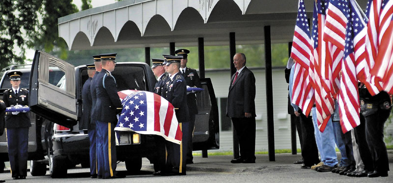 RETURN JOURNEY: Members of the Maine Army National Guard on Friday carry the casket of Pfc. Tyler M. Springmann, 19, of Hartland, who was killed in Afghanistan on July 17. Springmann's funeral was in the gymnasium at Nokomis Regional High School in Newport — the same place where he graduated last year.