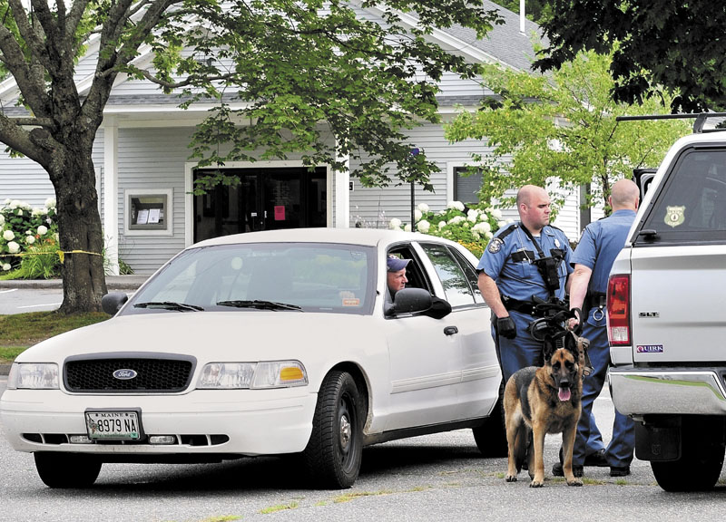 ROBBERY: State police troopers speak with Waldo County Sheriff Scott Story outside the Down East Credit Union on School Street in Unity after it was robbed on Friday afternoon. Police with tracking dogs searched neighborhoods and the woods for the robber.