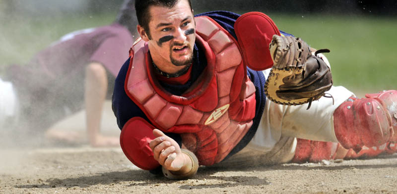 WHERE IS IT? Augusta catcher Jason Burns comes up looking for the ball after Brewer scored a run during an American Legion baseball state tournament game Wednesday in Augusta.