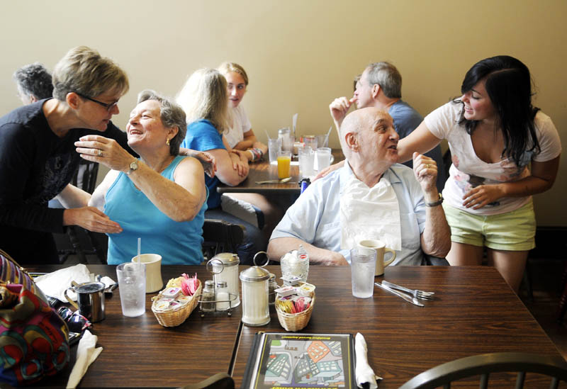 Rachael Stetson, right, greets her grandfather, James Welton, as her mother, left, MaryBeth Welton, hugs his wife, Elzabeth Welton, Monday at the Downtown Diner in Augusta. The recently opened cafe is attracted large number of diners, according to the proprietors.