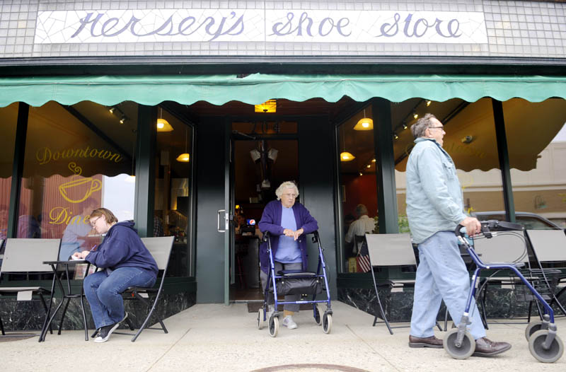 Customers exit the Downtown Diner on Water Street in Augusta, which features tables and chairs on the sidewalk.