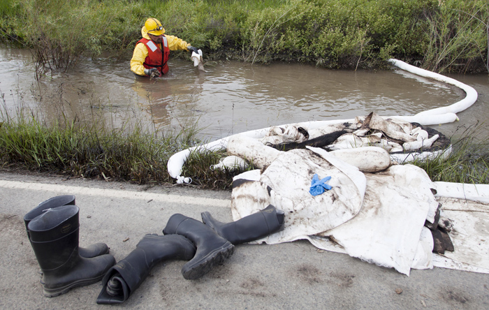 Cleanup crews work to collect oil from along side the Yellowstone River in Laurel, Mont., Monday.