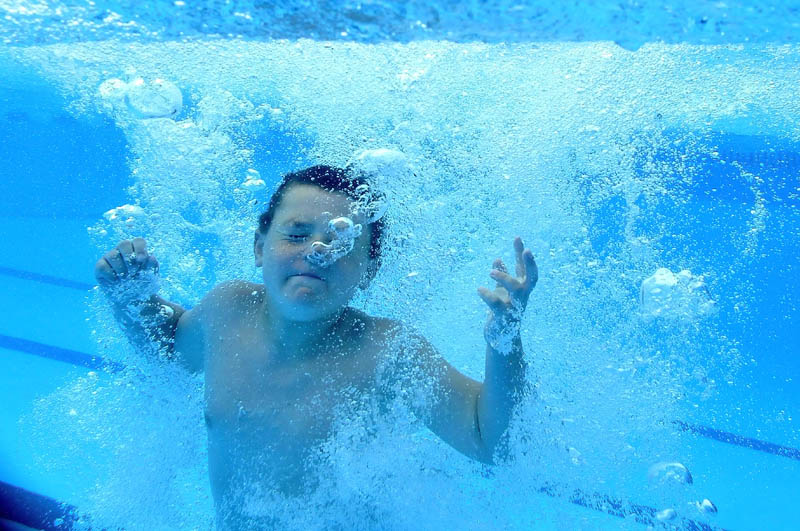 Ethan Caldwell, 8, of Albion, jumps in to the the Alfond Municipal Pool Friday to cool off from the warm summer temps in Waterville.