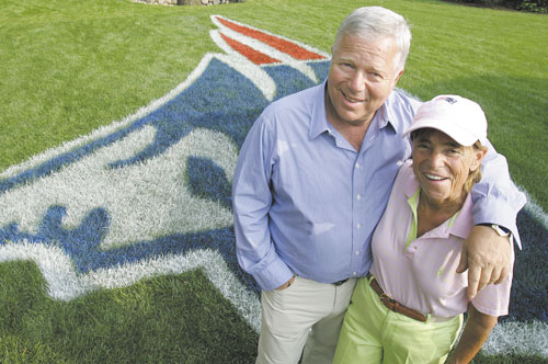In this June 22, 2005, file photo, PERFECT PAIR: New England Patriots owner Robert Kraft and his wife Myra pose in front of a Patriots logo painted on their lawn in Brookline, Mass., in 2005. Myra Kraft died Wednesday after a battle with cancer.