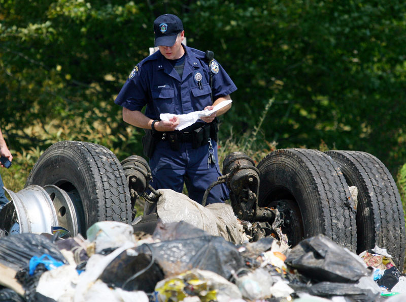 ACCESSING THE DAMAGE: A Maine state police officer inspects the remnants of a tractor-trailer that collided Monday with an Amtrak passenger train in North Berwick.
