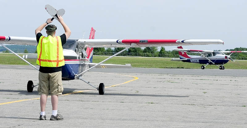 Civil Air Patrol cadet Avery Spear directs a plane’s crew into position on Tuesday at the Augusta State Airport.