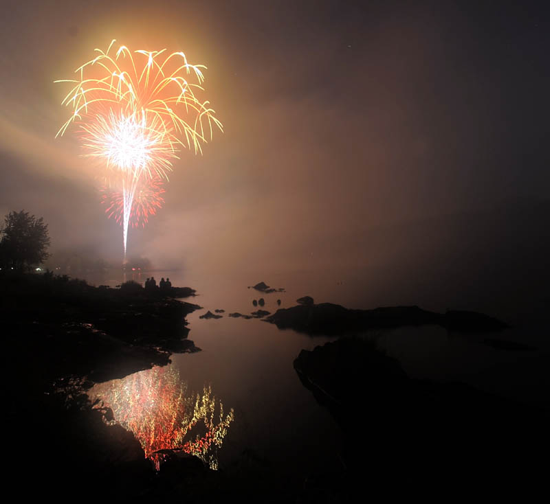Staff photo by Michael G. Seamans Fireworks light up the sky over the Kennebec River during Independence Day celebration in Winlow Monday.