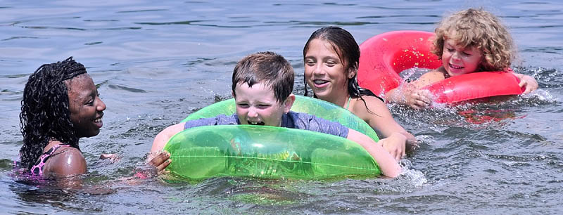 Idasia Santos, left, Bryce Dupont, Kianna Pushard and Zackary Dupont swim in Lower Narrows Pond on Tuesday afternoon at More To Life Campground in East Winthrop. Santos, of the Bronx, NY, is staying with the Pushard family as part of the Fresh Air Fund program.
