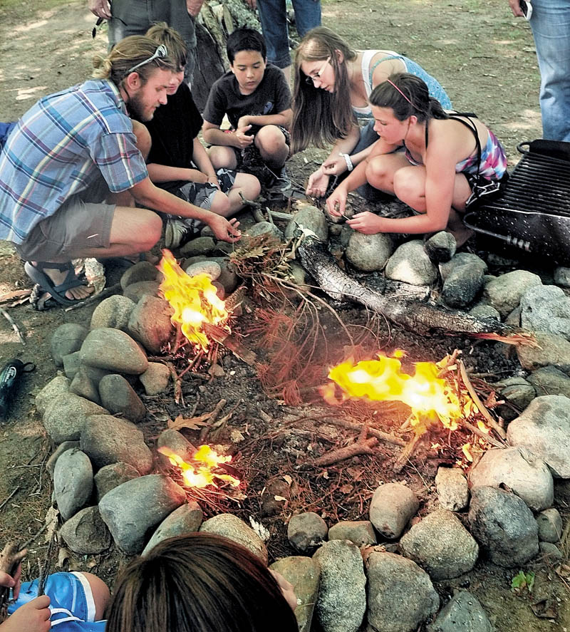 Camp Loon kids take part in a fire starting contest during the close of a two-week Survivor Island program at the Belgrade Community Center for All Seasons in Belgrade on Friday.