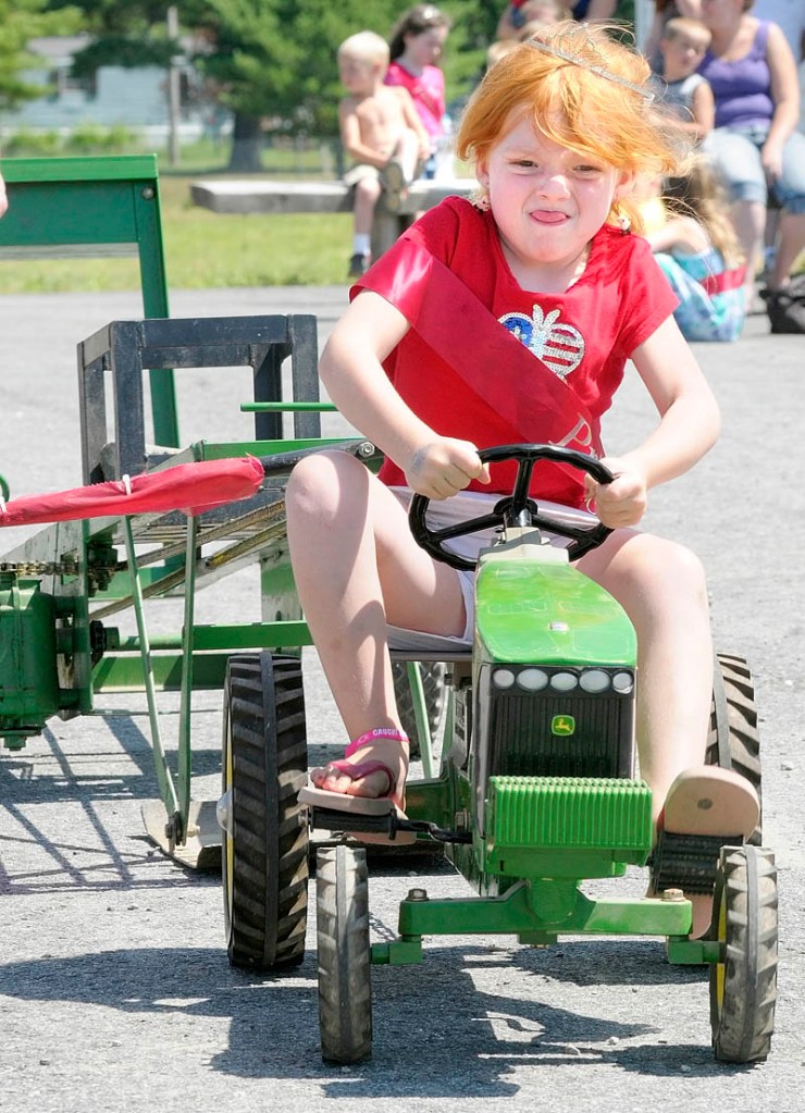 Caleigh Crocker, 5 of Windsor, strains to pedal in the kiddie tractor pull contest on Saturday morning at the Pittston Fair. The fair runs through this afternoon and is located on Route 194 near Mast Road.