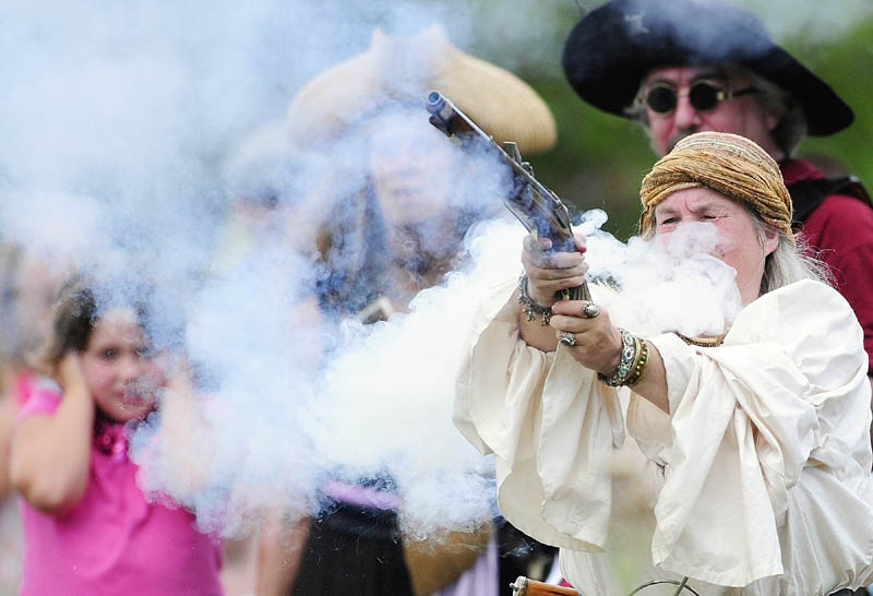 A young spectator covers her ears as cannons and guns fire during a pirate battle on Saturday during Richmond Days events at Fort Richmond Waterfront Park.