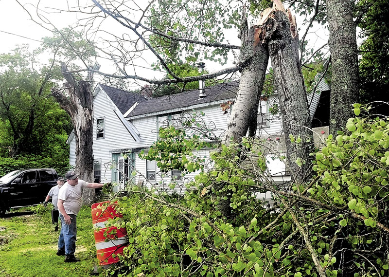 POWER OUT: Homeowner Carl Hannon, front, and neighbor Pat Welch observe a poplar tree that was struck by lightning and broke in half during a storm Wednesday in Benton. The tree snapped power, cable and telephone lines and caused serious damage after it hit the pickup truck in the background.