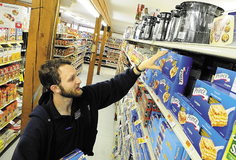 Jonathan Pelton stocks shelves on Wednesday afternoon at Hussey’s General Store in Windsor. Pelton, of South China, is working there on summer break from college and has been employed there since high school.
