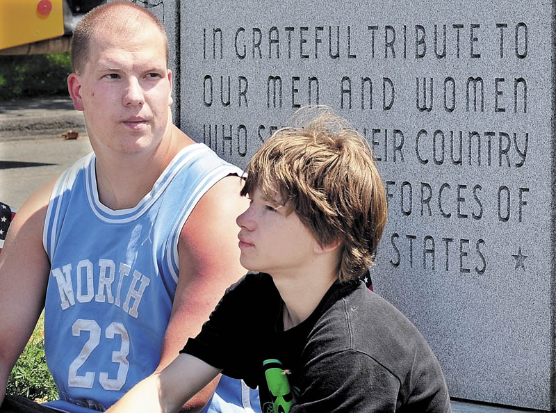 FAMILY AND FRIENDS: Justin Bennett and Zachary Martin, right, remember Tyler Springmann on Tuesday at a veterans monument in Hartland. Springmann, Zachary’s brother, was killed Sunday while serving in the U.S. Army in Afghanistan.
