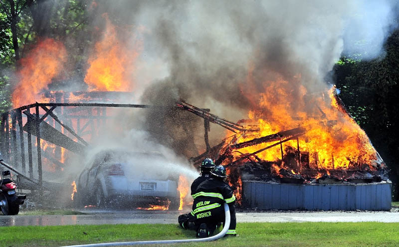 ALL GONE: Winslow firefighters spray water that engulfed a mobile home and vehicle owned by Priscilla Ouellette, 64, on Friday at the Pleasant Ridge Mobile Home Park in Winslow. Ouellette grabbed her dog, Mackey, and escaped without injury.