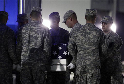 KILLED IN AFGHANISTAN: An Army carry team carries the transfer case containing the remains of Army Spc. Mark J. Downer of Warner Robins, Ga., upon arrival at Dover Air Force Base, Del., on Saturday.