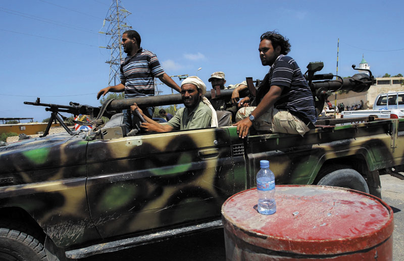 TO THE FRONT: Libyan rebels speed toward the fighting in the village of Mayah, just west of Tripoli, on Sunday,