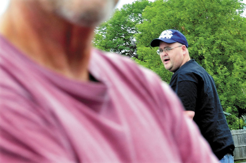 IN WATERVILLE: Republican mayoral candidate Andrew Roy is shielded by a man during an interview at roy's residence on Monday. Roy said in an online comment Sunday that he has changed his mind and is still a candidate after earlier saying he was not running.