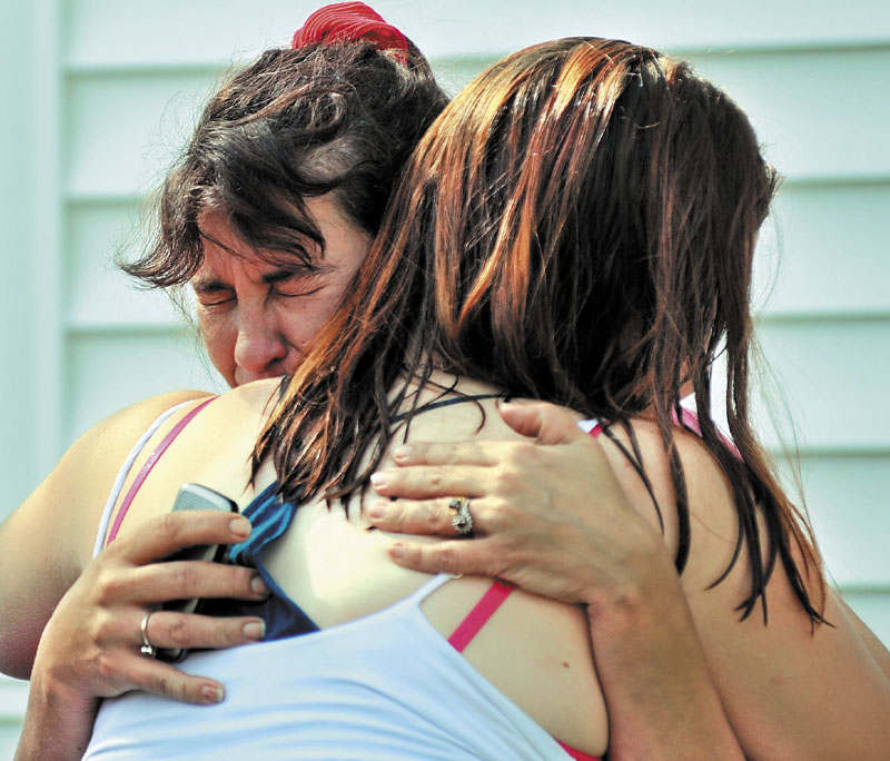 EMBRACE: Tracey Bragdon, left, owner of the Oak Street home destroyed by fire Tuesday morning in Waterville, is consoled by a friend as firefighters battle the blaze.