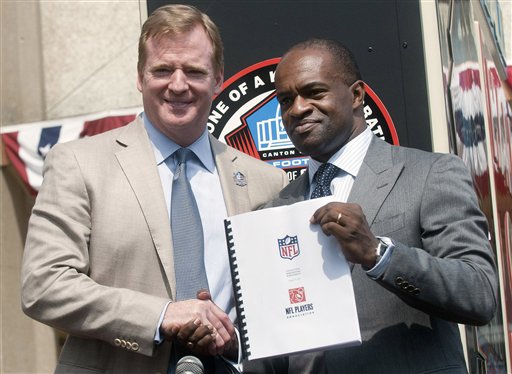 NFL Comissioner Roger Goodell, left, and NFLPA Executive Director DeMaurice Smith, shake hands after signing their collective bargaining agreement Friday at the Pro Football Hall of Fame in Canton, Ohio.