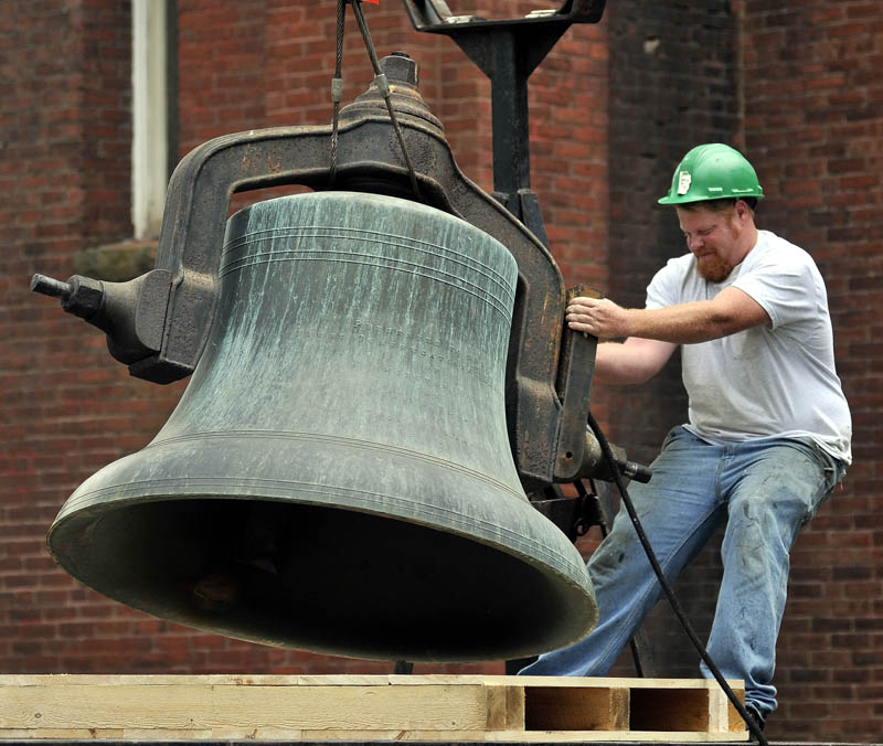 Andrew Wilcox, with MMR Professional Steeplejacks, guides the 100-year-old, 3,000-pound Meneely bell onto a waiting truck Wednesday at the Old South Congregational Church on Main Street in Farmington. The bronze bell, which measures 53 inches in diameter, is being shipped to Ohio for restoration.